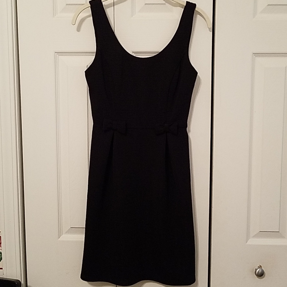 Adorable black tank dress with bow waist detail.